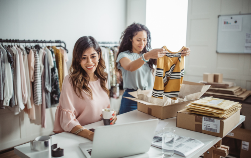 Two women managing an eCommerce business, packing orders and working on a laptop, showcasing time-saving tools for sellers.